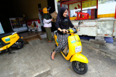 Shift gear: a woman rides a yellow Migo electric bike in this file photo dated Feb. 13, 2019. 