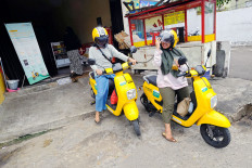 Mellow yellow: Two Jakartans try out the electric bicycles provided by China-based rental app Migo at one of its stations in Kota Bambu Utara, Palmerah, West Jakarta on Wednesday. The electric bicycle entered Jakarta in December last year.