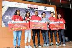 PB Djarum badminton club shuttlers Aisha Galuh Maheswari (left), Alifia Intan Nurokhim (second left), Leo Rolly Carnando (second right) and Indah Cahya Jamil Sari (right) share a stage with Djarum Foundation officer Yoppy Rosimin (third right) and a Li Ning representative (third left) during an event held to give bonuses to the shuttlers in Jakarta.