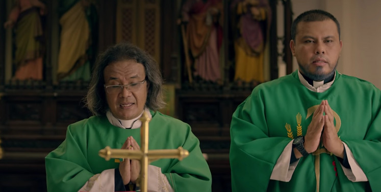 Prayers: Director Joko Anwar (left) makes an appearance as a Catholic priest. 