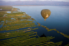 This aerial photo taken from a hot air balloon shows a hot air balloon flying over Inle lake in Shan State on February 18, 2019. 