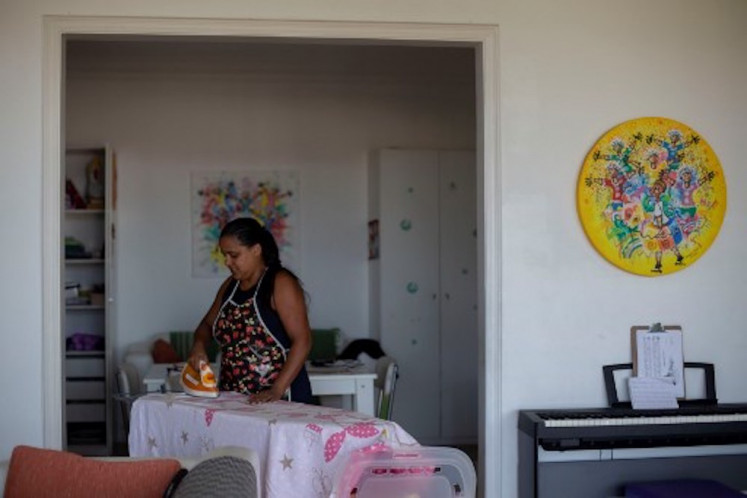 Domestic worker Fabiana Barbosa de Souza, 36, irons at the house where she works twice a week at Laranjeiras neighborhood, southern Rio de Janeiro, Brazil on January 11, 2019. The working conditions of domestics in Latin America, to whom director Alfonso Cuaron pays homage in his recent movie 'Roma', is slowly reaching a legal framework. Whilst several countries in the region have established laws for the sector in the last decade, other simultaneous realities such as economic crises and migration, are hampering those conquests and ambitions of formality.