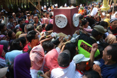 Crunch time: Residents scramble for 1.000 portions of jenang around a replica of Surakarta's clock monument. JP/Maksum Nur Fauzan