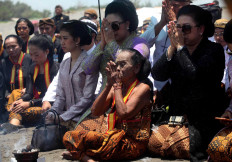 Solemn: Two daughters of Pakubuwono XII, GKR Koes Moertiyah (right) and GKR Koes Indriyah (left), along with a senior female royal servant, pray. JP/ Boy T Harjanto