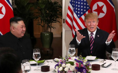 US President Donald Trump gestures as he and North Korean leader Kim Jong Un sit down for a dinner during the second US-North Korea summit at the Metropole Hotel in Hanoi, Vietnam February 27, 2019. 