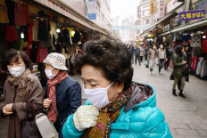 Shoppers wearing face masks walk through a market during heavily polluted weather in Seoul on Tuesday. 