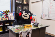 Kumamon says hi to tourist in his office in Kumamoto, Japan.