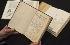 A member of staff poses holding a first edition copy of 'Harry Potter and the Philosopher's Stone' by British author J K Rowling annotated by Rowling that will form part of the 'English PEN First Editions, Second Thoughts Sale' at Sotheby's auction house in central London on May 20, 2013. 