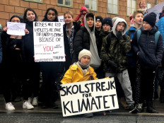 Swedish 16-year-old environmental activist Greta Thunberg (in yellow coat) attends a protest next to Sweden's parliament in Stockholm, Sweden, on March 8, 2019. The sign reads 'School strike for the climate'. 