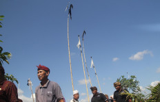 Farmers walk passing the pindekan and sunari (bamboo poles with bells on the top). JP/Zul Trio Anggono 