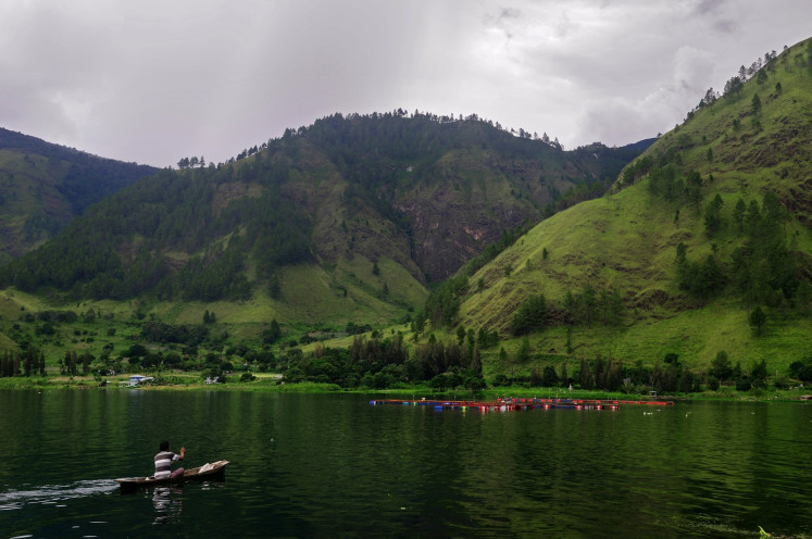 Serene moment: A fisherman floats by on Lake Toba in North Sumatra.