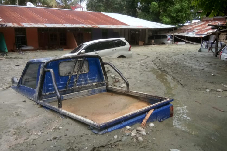 Vehicles are seen immersed in mud after flooding in Sentani, Jayapura, Papua on Sunday.