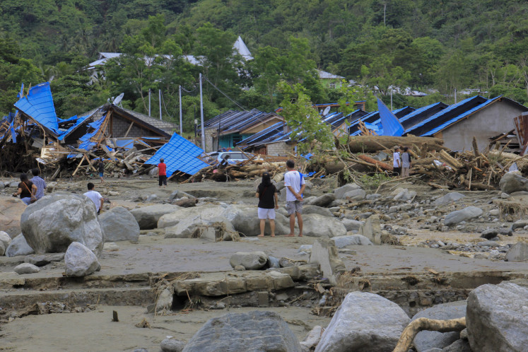 Warga memeriksa rumahnya yang hancur akibat banjir di Sentani, Jayapura, Papua, Minggu.  Sekitar 50 orang tampaknya kehilangan nyawa akibat banjir. 