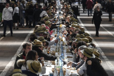 People take part in an attempt to break the Guinness World Records of the longest table to celebrate the international food market of Rungis' 50th anniversary, on March 17, 2019 in Rungis, outside Paris.  