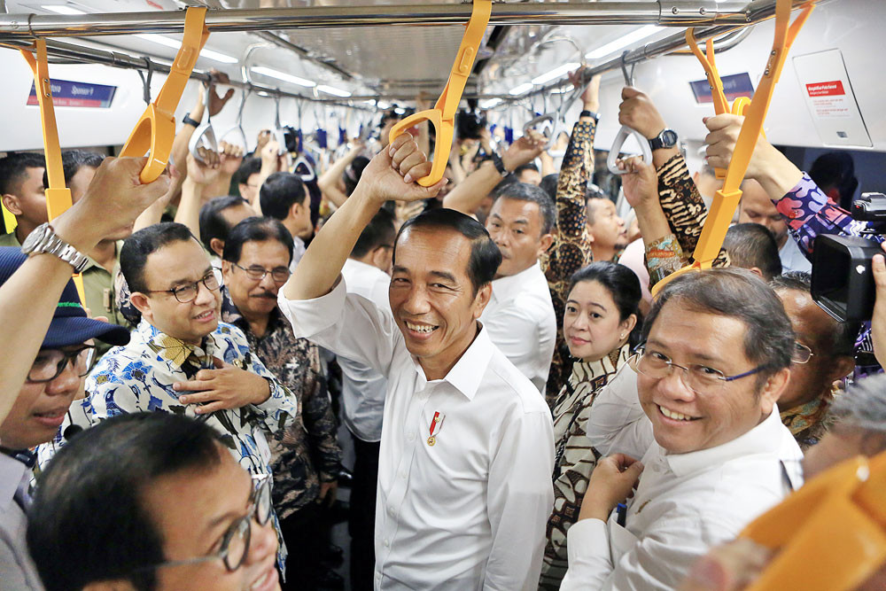 President Joko “Jokowi” Widodo (center), several Cabinet ministers and Jakarta Governor Anies Baswedan (second left, in white and blue batik) ride the MRT Jakarta from Bundaran HI Station in Central Jakarta to Lebak Bulus in South Jakarta on March 19. Image: The Jakarta Post/Seto Wardhana