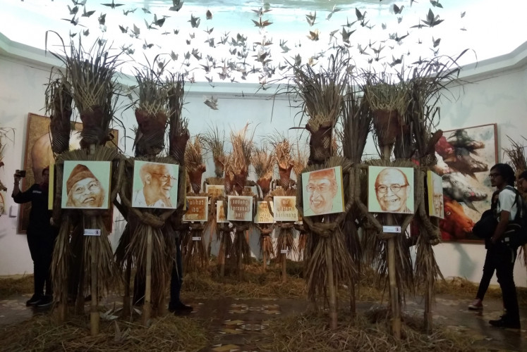 Origami birds hang above an installation art at Hari Budiono's 'Memedi Sawah' exhibition to evoke a rice field. 