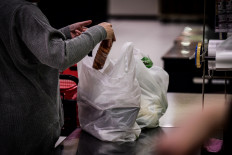 In this picture taken on November 7, 2018, a woman packs her shopping into a plastic bag in a supermarket in Chiba. From bento boxes to individually wrapped bananas, plastic reigns supreme in Japan. But amid global concern about single-use waste, new legislation could help end the country's love affair with plastic.
