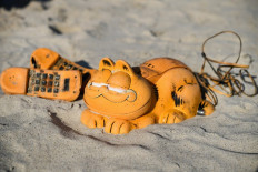 Spare parts of plastic 'Garfield' phones are displayed on the beach on March 28, 2019 in Plouarzel, western France, after being collected from a sea cave by environmental activists. 