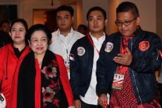 Indonesian Democratic Party of Struggle (PDI-P) chairwoman Megawati Soekarnoputri (second left) and the party's secretary-general Hasto Kristiyanto (right) walk together at a party event in this undated file photo taken in Jakarta.