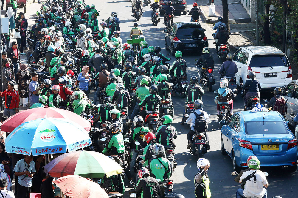 Traffic is held up as app-based ojek (motorcycle taxi) drivers wait to pick up passengers at Palmerah Station in Central Jakarta.
