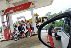 A gas station worker serves customers in the West Papua city of Bintuni in April 2019.