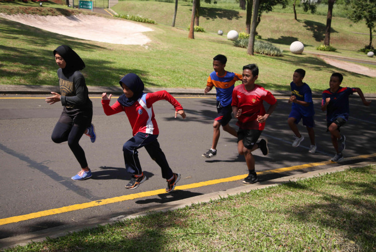 Accelerate: Students in Depok run up a hill as part of their running training program.
