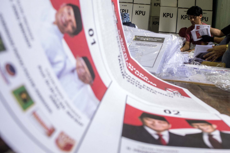 Officials sort and fold ballots for the 2019 presidential election at a General Elections Committee (KPU) warehouse at STT Mandala University in Bandung, West Java, on April 1, 2019.
