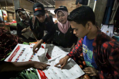 Volunteers at the Lhokseumawe Independent Elections Commission (KIP) show residents ballot samples at the Lhokseumawe Inpres traditional market in Aceh on April 1. The event introduced five types of ballots as well as voting and folding procedures in order to boost voter turnout and spread awareness about residents’ voting rights. Antara/Rahmad
