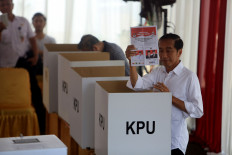 Incumbent President Joko Widodo shows the ballot paper at a polling center during the presidential and legislative election in Jakarta on April 17, 2019.