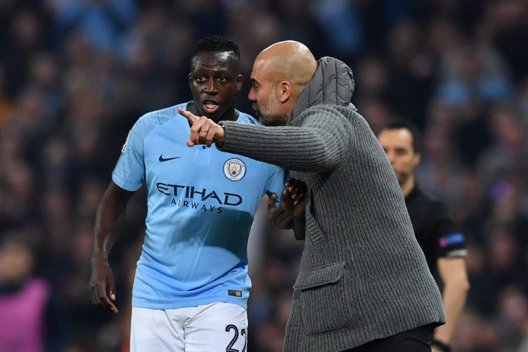 Manchester City's Spanish manager Pep Guardiola gestures to Manchester City's French defender Benjamin Mendy during the UEFA Champions League quarter final second leg football match between Manchester City and Tottenham Hotspur at the Etihad Stadium in Manchester, north west England on April 17, 2019. 
Ben STANSALL