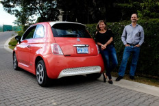 In this file picture taken on March 16, 2019 Costa Rican Erick Orlich, president of the Costa Rican Electric Mobility Association, poses next to his wife Gioconda Rojas and their electric car during an interview with the AFP in San Jose. The National Decarbonization Plan presented by Costa Rican President Carlos Alvarado aims at transforming the economy with the basis of an electric matrix of renewable resources by 2050. It aspires to have industry, agriculture and cattle raising operating with non-polluting energy resources, and to increase forest areas to 60% of the national territory, from the current 50%.