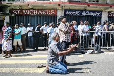 Grieving: People pray outside the St. Anthony’s Shrine in Colombo on Monday, a day after the building was hit as part of a series of bomb blasts targeting churches and luxury hotels in Sri Lanka. The death toll rose dramatically to 290 -- including dozens of foreigners -- as police announced new arrests over the country’s worst attacks for more than a decade.