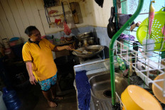 Local favor: Ida Padua cooks crab chips at her home in Argosigemerai village in Teluk Bintuni regency, West Papua. Ida tries to improve her family's finances by selling crab chips. JP/Jerry Adiguna