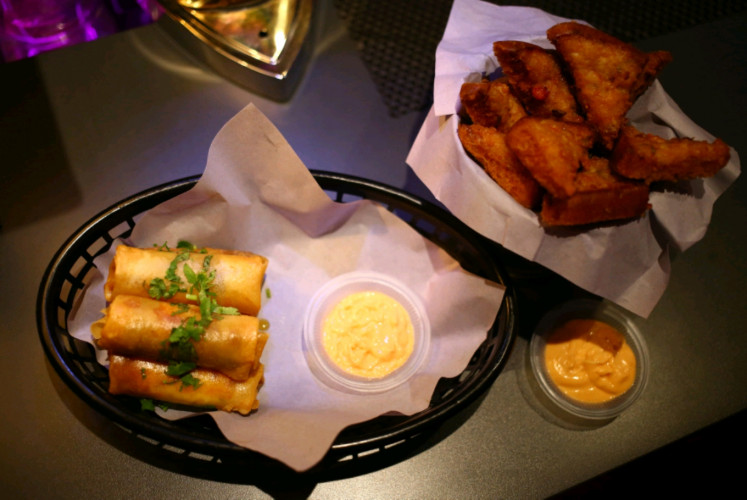 Snacks serves at Slits. include the crunchy cheese burger roll with a generous filling (left) and the crispy, savory shrimp toast.