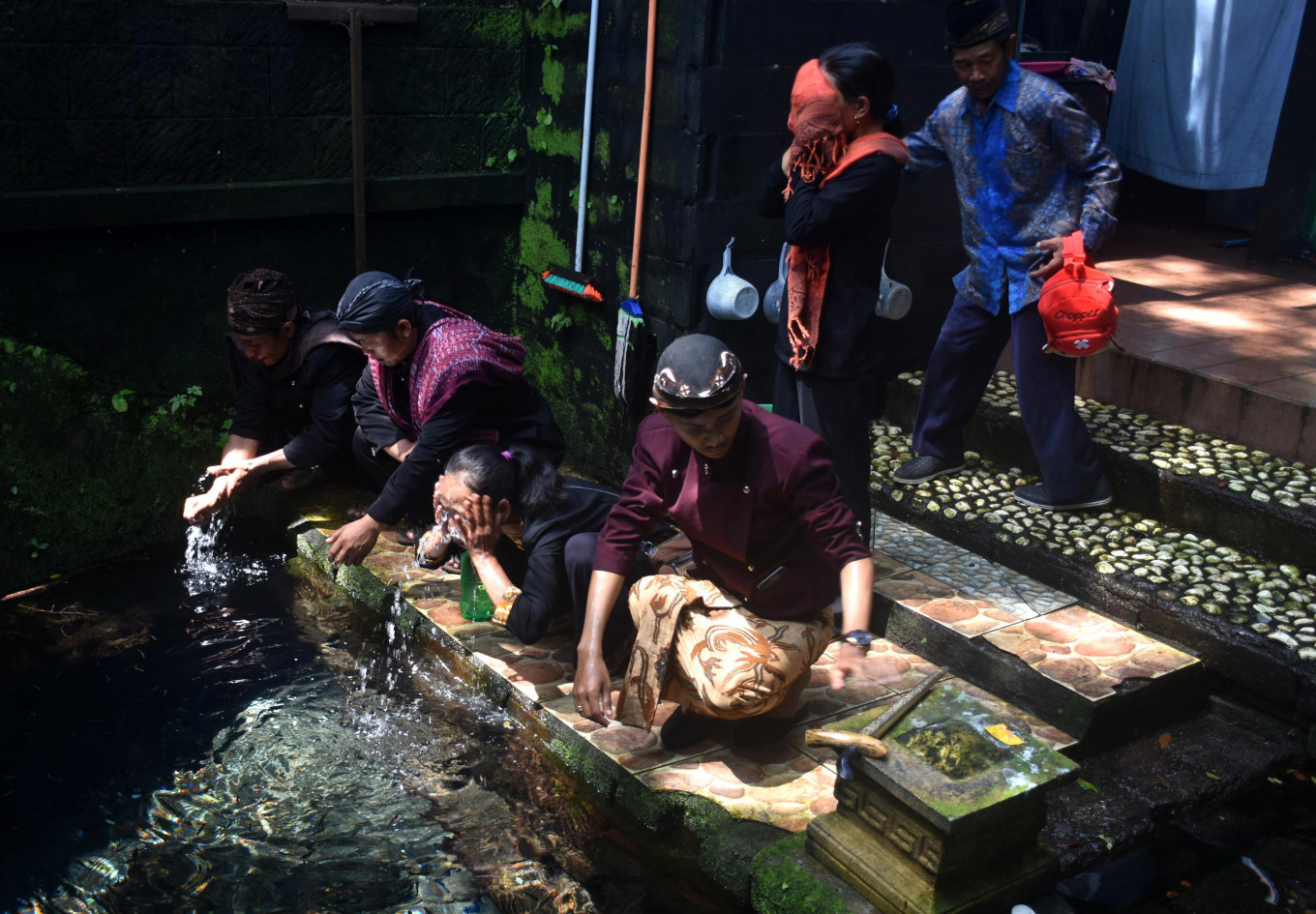 Para peserta dan penduduk setempat mengambil air untuk mencuci muka dan tangan mereka | Foto: Aman Rochman / Jakarta Post