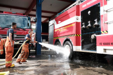 Members of the West Jakarta Fire and Rescue Agency clean pumper trucks that can carry 10,000 liters of water at their station in Kembangan, West Jakarta.