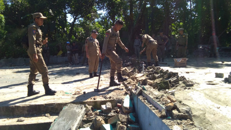 Bogor Public Order agency (Satpol PP) personnel stand near the rubble of demolished buildings in Kemang district, Bogor regency, West Java, on May 2. The agency tore down 22 karaoke parlors ahead of Ramadan as part of a policy that prohibits entertainment places from operating during the holy month.