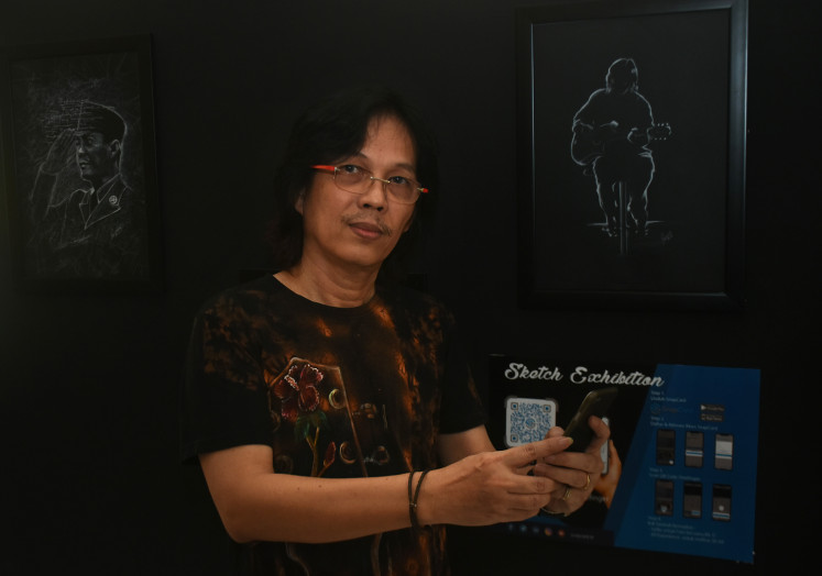 Guitarist Doddy Hernanto shows his sketches at the art exhibition.