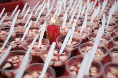 A candle helps ward off flies from the sweet beverages prepared for iftar in the temple. JP/Donny Fernando