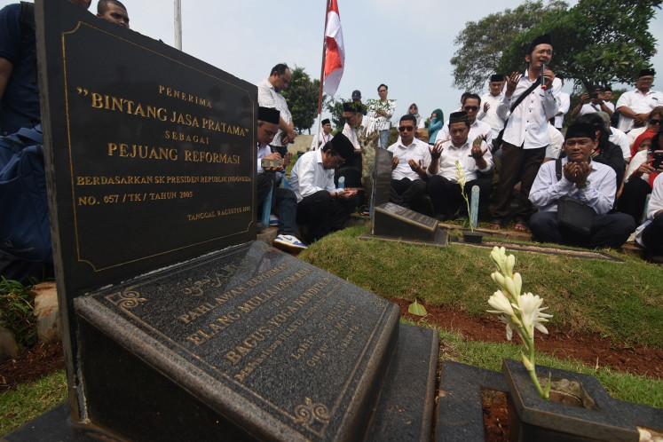 Activists pay a visit to the graves of two of the Trisakti college students killed in the May 1998 shootings, Elang Mulya Lesmana and Hery Hartanto in Tanah Kusir public cemetery in South Jakarta, to commemorate the 21st anniversary of the tragedy on May 12, 2019. 