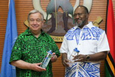 United Nations Secretary-General Antonio Guterres (L) and Vanuatu's Prime Minister Charlot Salwai (R) holding water bottles to promote an end to plastic bottle use in Port Vila, the capital of Vanuatu on May 18, 2019. 