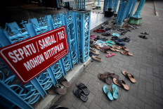 A sign calls on pilgrims to put their sandals, shoes and bags in lockers. JP/Boy T. Harjanto