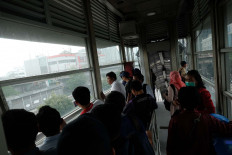 Transjakarta bus passengers hide in a shelter during the unrest in Slipi, West Jakarta. [JP/Jerry Adiguna