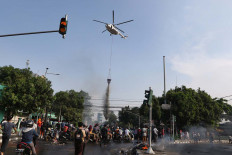 A helicopter water bombs the crowd in Petamburan, Central Jakarta. JP/Dhoni Setiawan