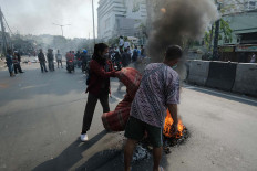 Two men burn a mattress in Kebon Pala, Central Jakarta. JP/Jerry Adiguna
