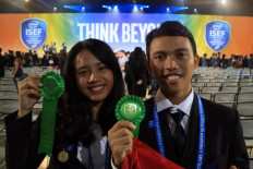 Carolline Mathilda Nggebu and I Made Wiratathya Putramas show off their awards. The high school students received the fourth Grand Award at Intel ISEF 2019 for developing antifouling paint out of mangrove plants. 