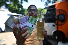 Jakartans line up for crisp small bills ahead of Idul Fitri