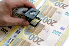 A worker checks the new 200 euro bills during the printing procedure in the Bank of Italy’s high-security factory in Rome, Italy. 