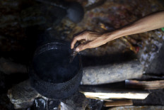 A batik worker uses canting(a pen-like tool) to obtain liquid wax. JP/Sigit Pamungkas