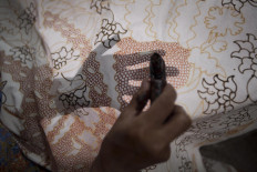 A worker draws according to the pattern in the batik-making process. JP/Sigit Pamungkas
